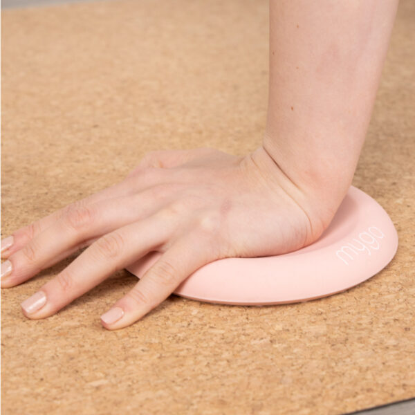 Pink Yoga Support Jelly Pad being used on a cork yoga mate