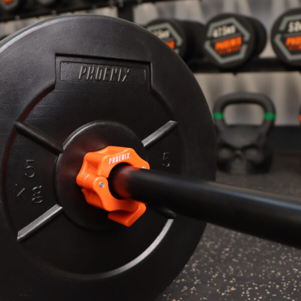 A lifestyle image of the 1 inch orange barbell collar on a black standard bar