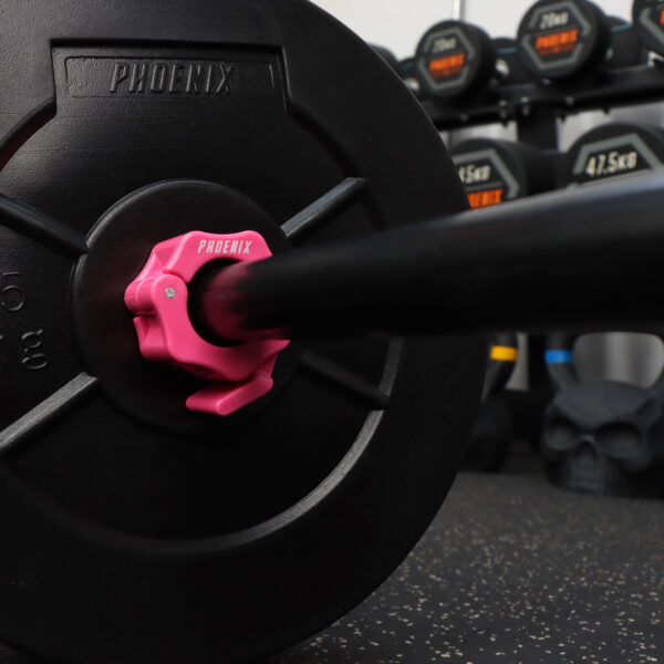 A lifestyle image of the 1 inch pink barbell collar on a black standard bar